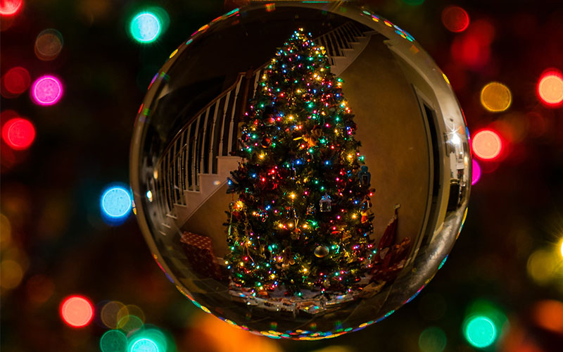 Tips for Christmas content videos - Christmas tree seen in the reflection of a bauble